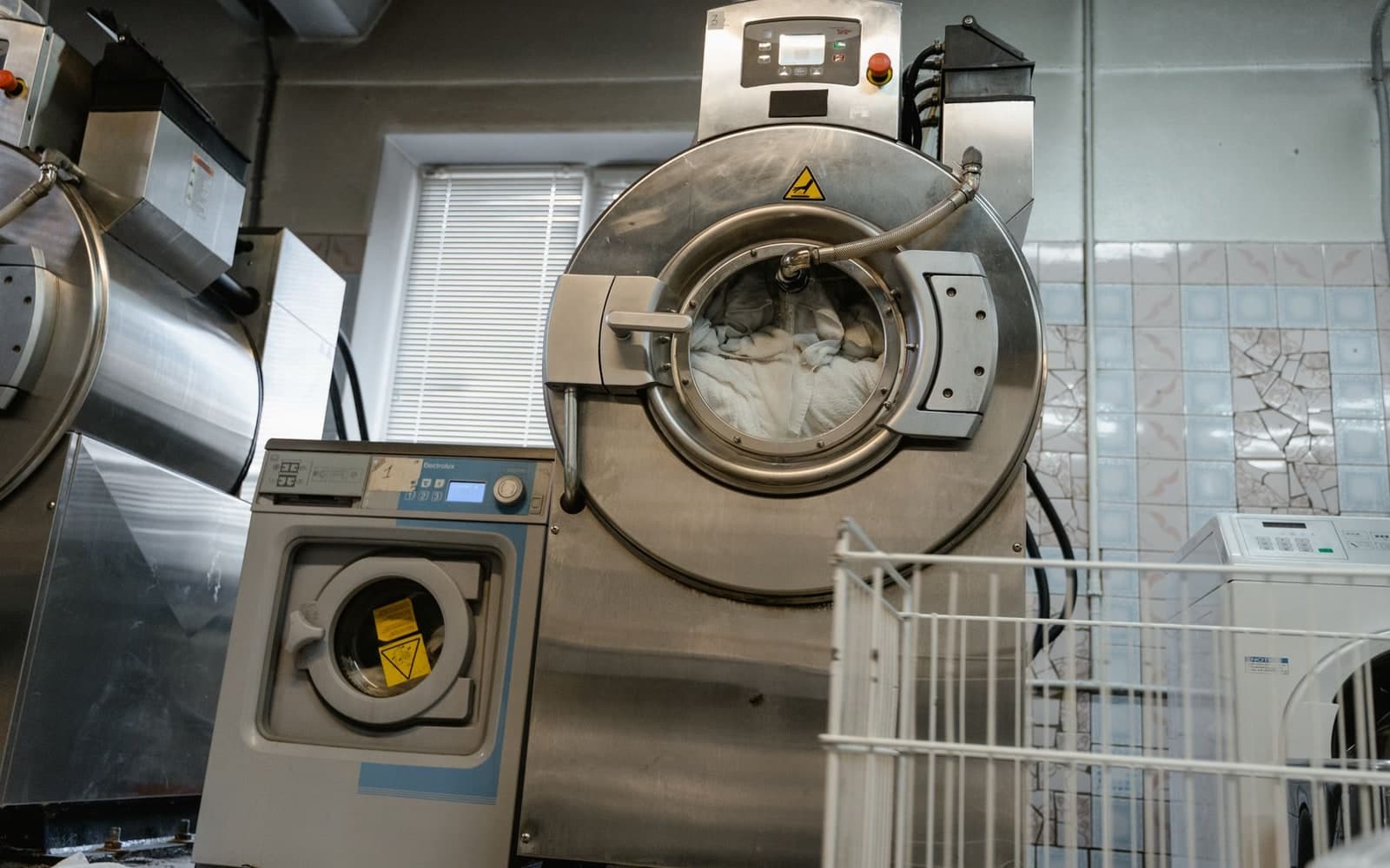Large front-loading industrial cleaning machines in a commercial laundry room