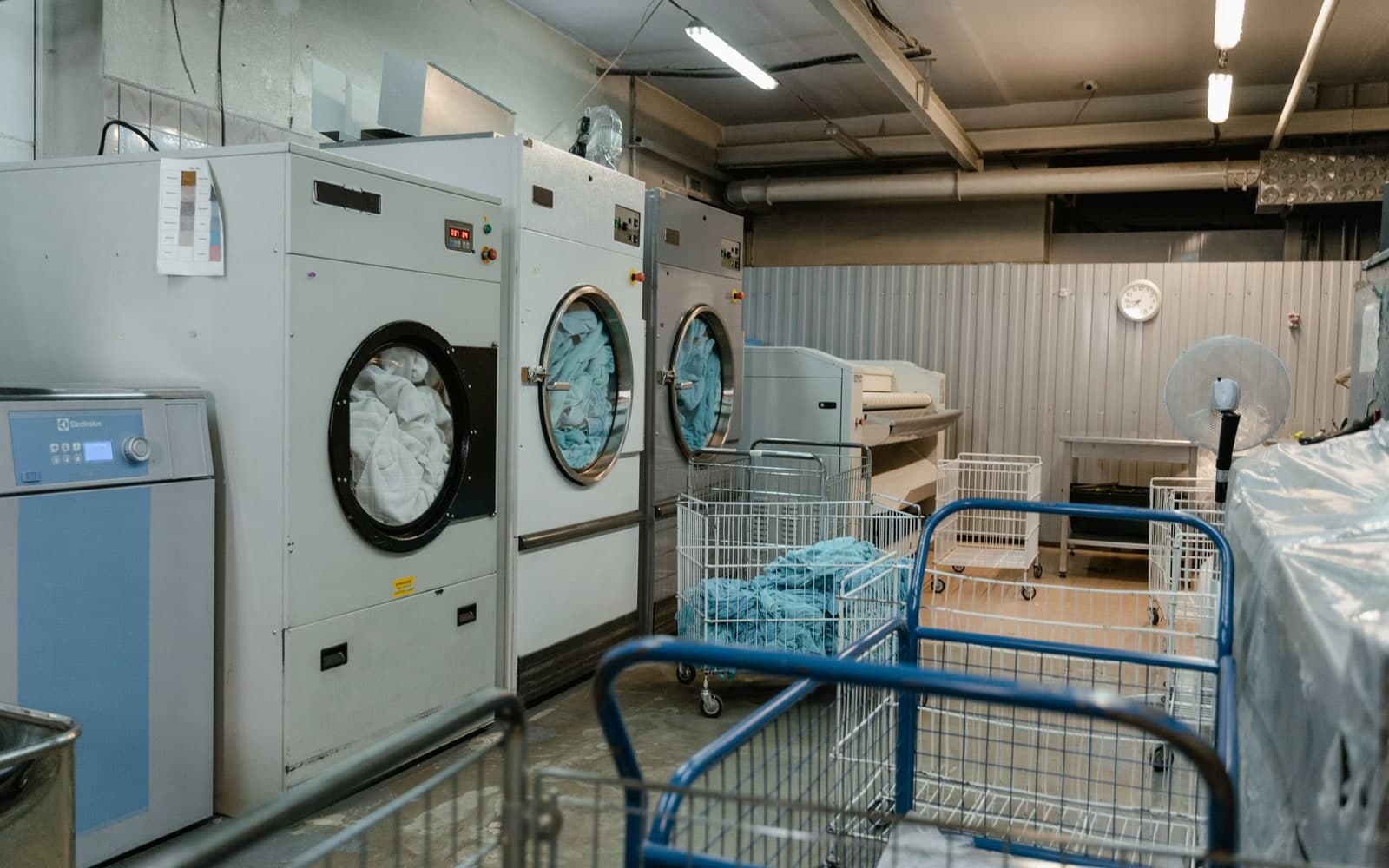 Industrial washers with laundry carts in a commercial laundry service area