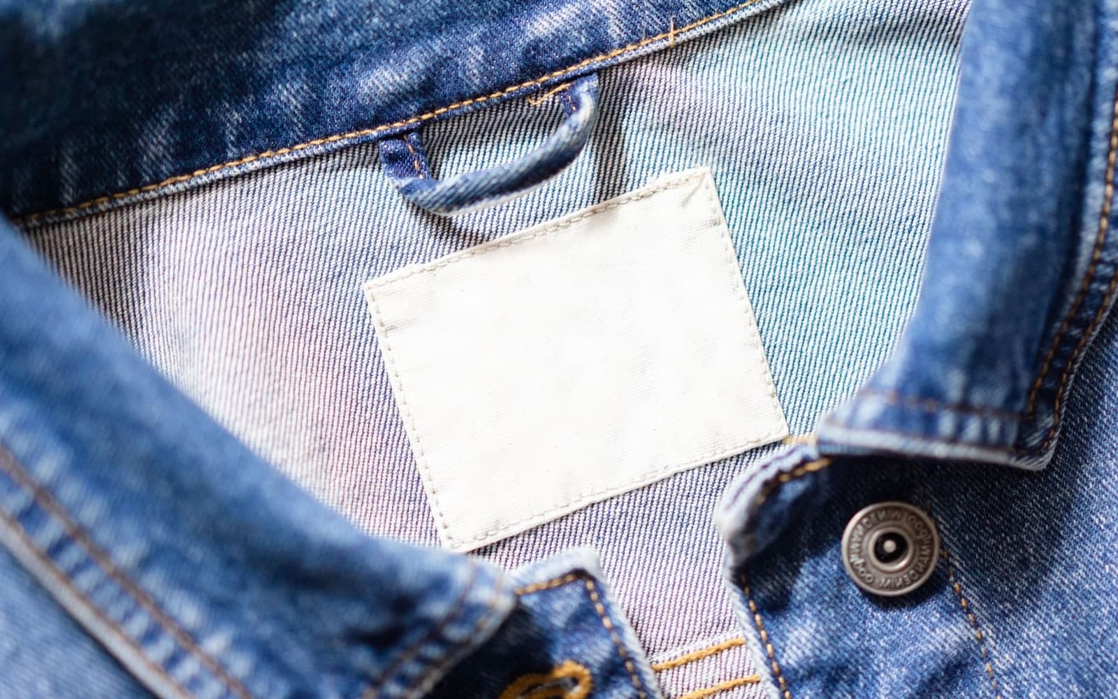 Close-up of a blank white label on a denim collar