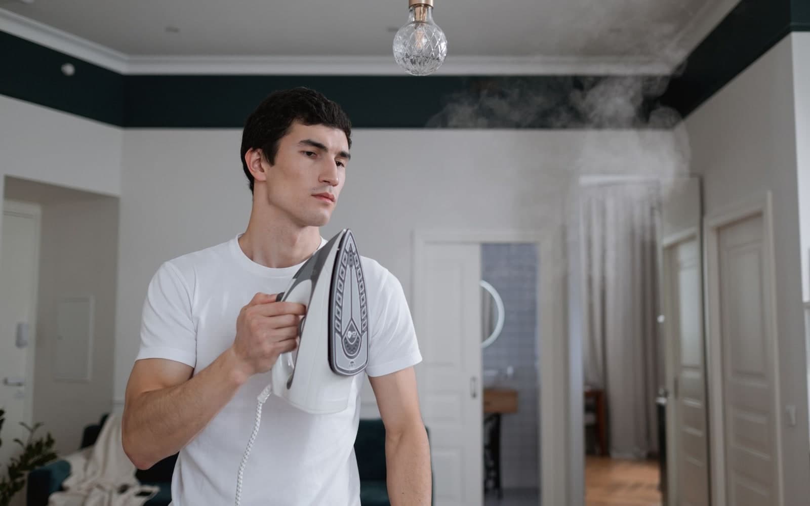 Steam iron emitting a burst of steam over a white shirt