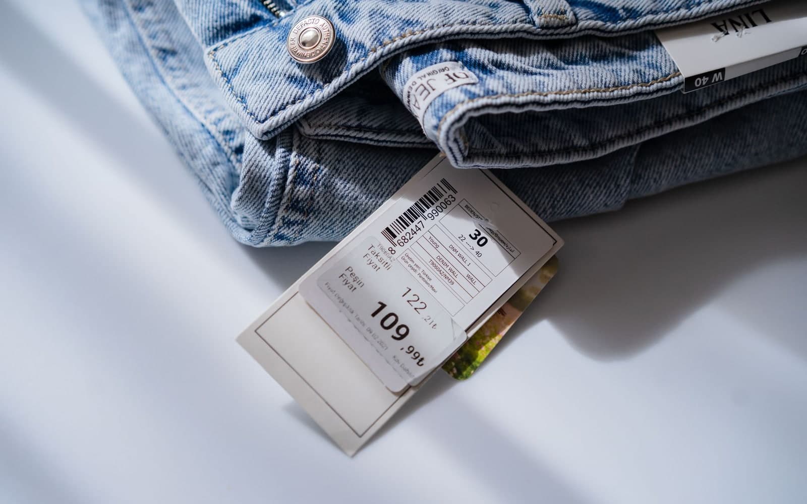 Barcoded price and size ticket attached to folded jeans