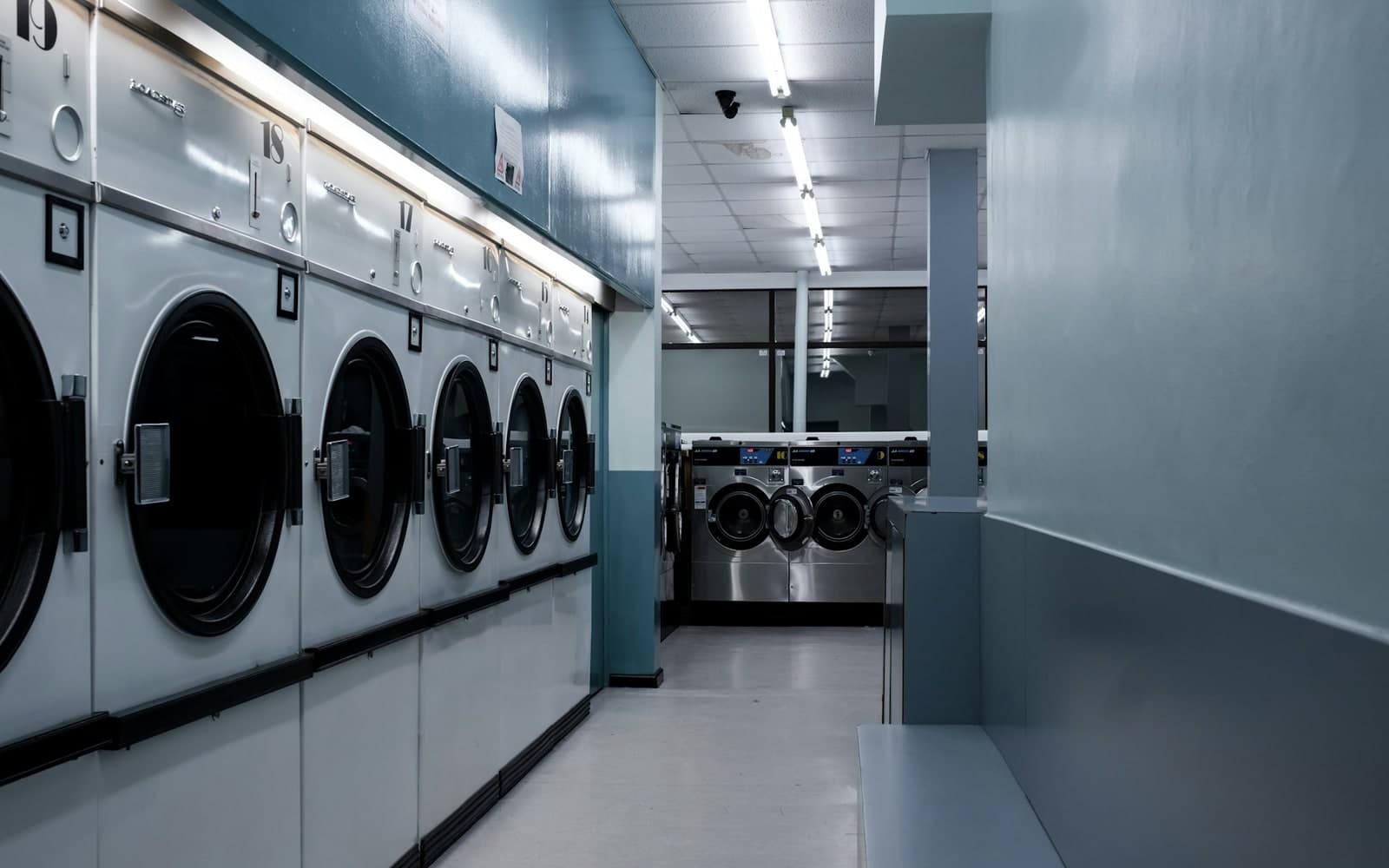 Row of white front-load washing machines in a laundrette