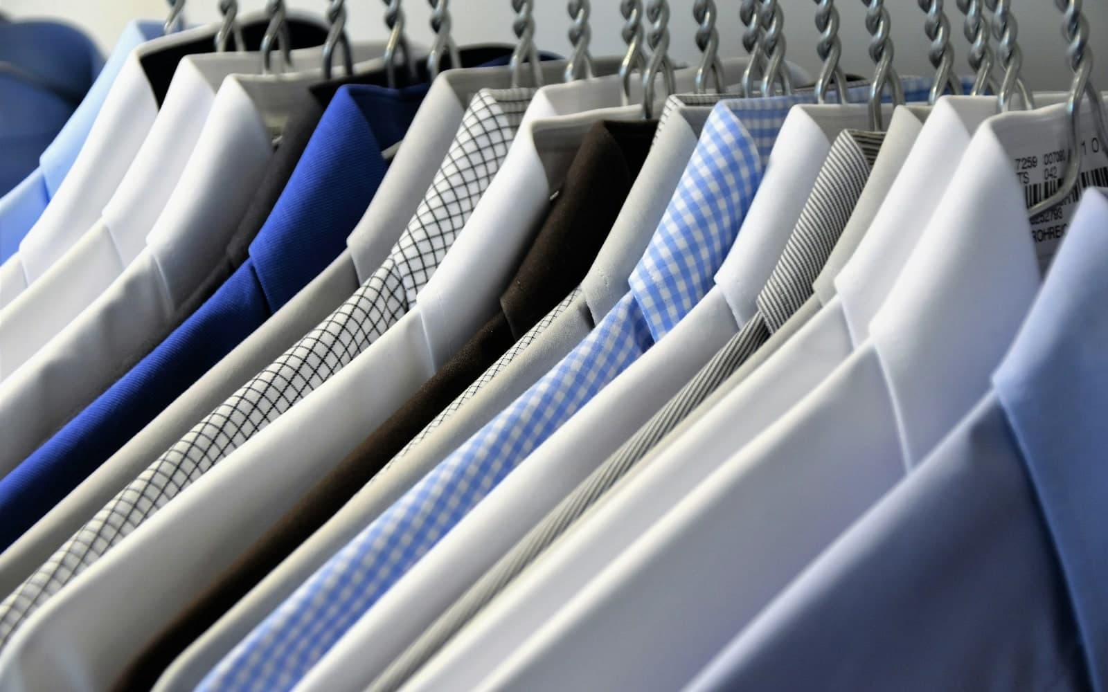 Pressed dress shirts in assorted colours hanging on a rail