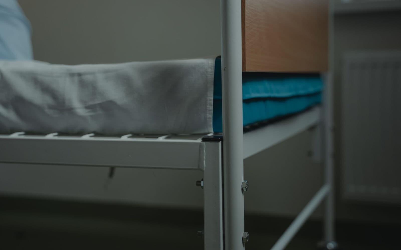 Hospital bed with crisp white linen and a metal frame