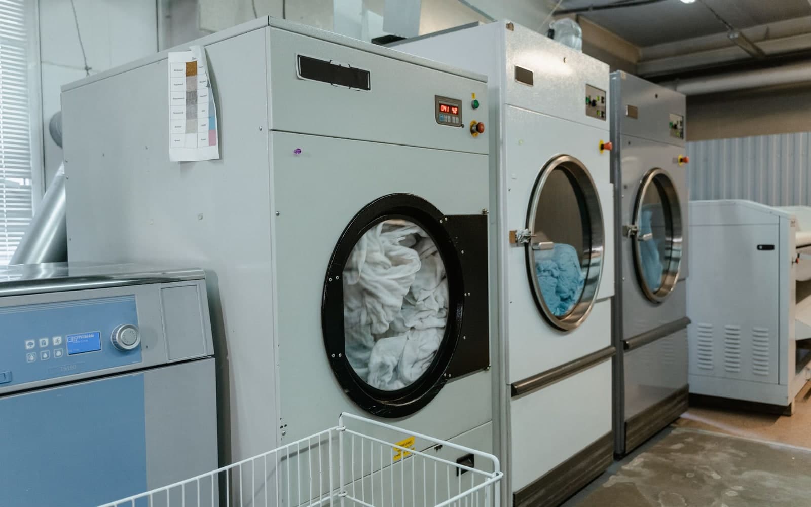 Industrial washer-extractors lined up in a commercial laundry