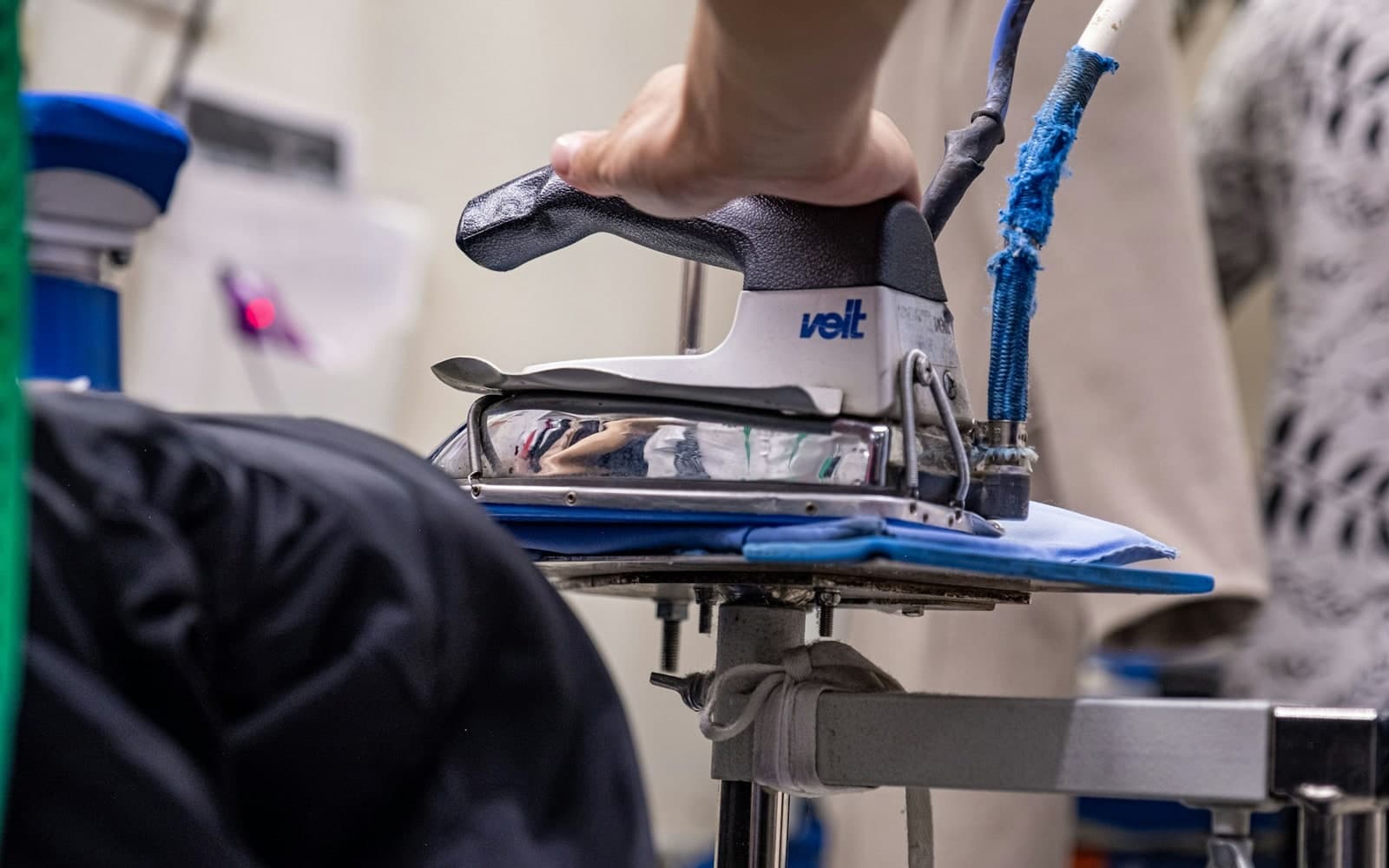 Close-up of a professional pressing a shirt with a steam iron