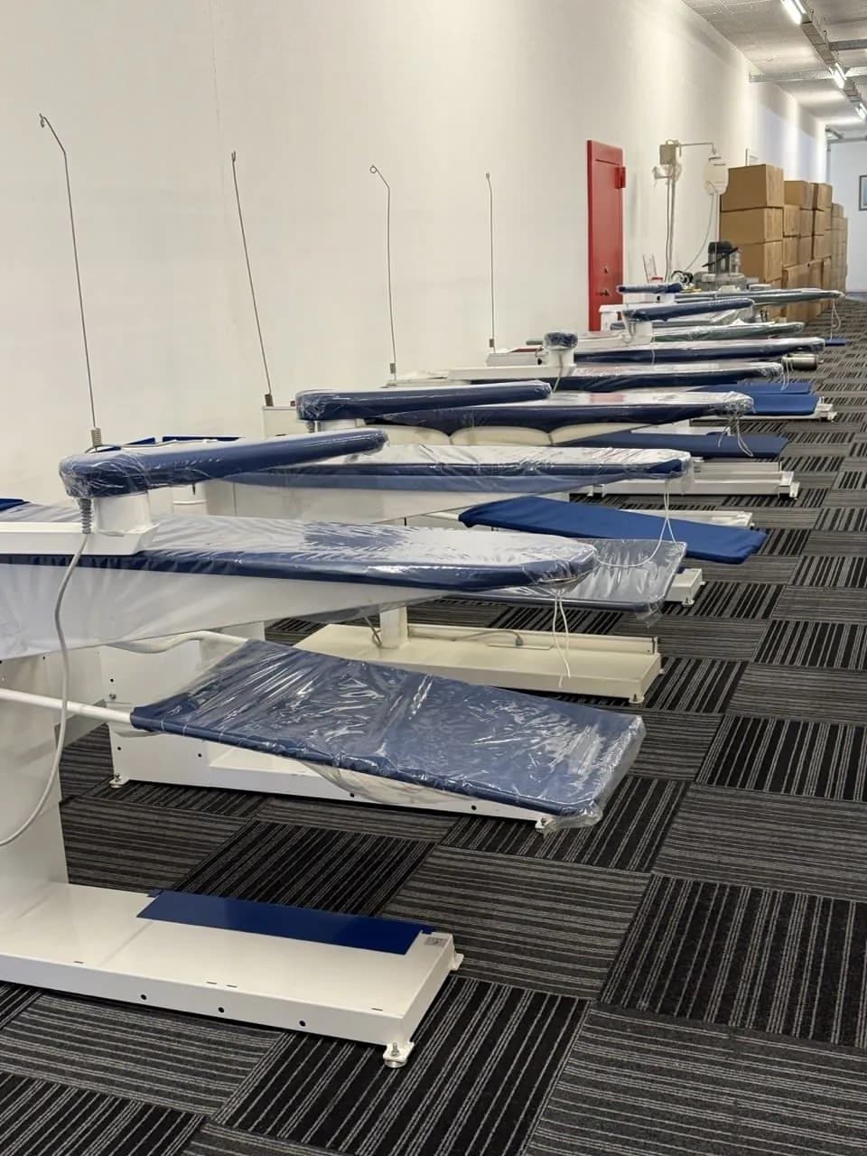 A row of vacuum ironing tables set up for pressing